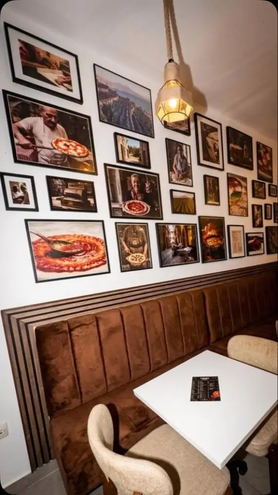 Enterijer Forno Venta sa uramljenim fotografijama na zidu